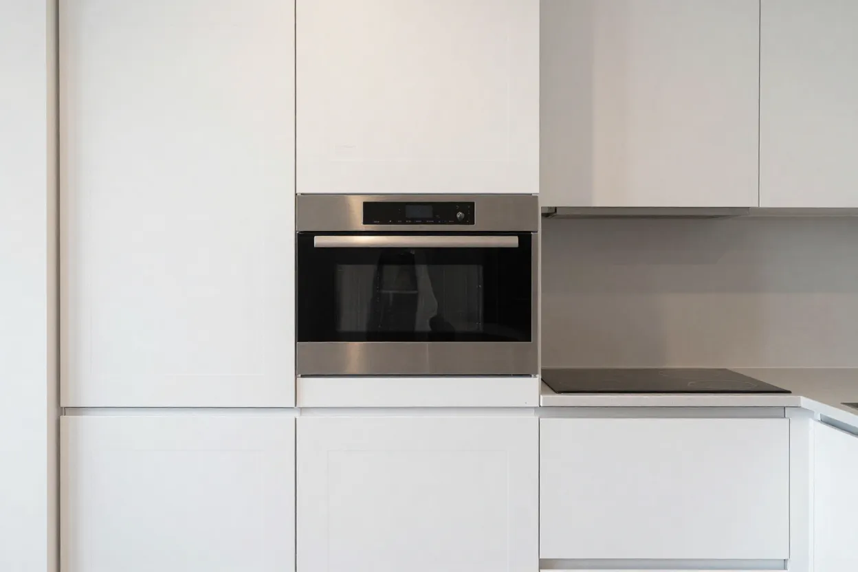 Cozinha compacta com eletrodomésticos embutidos e integrados aos armários